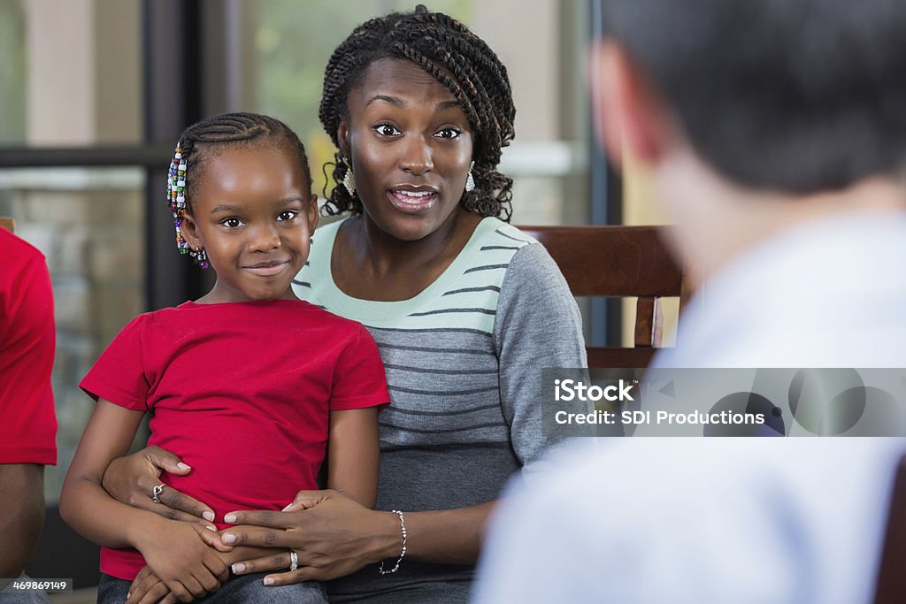 Mother and daughter talking with counselor during family counseling session Family Stock Photo