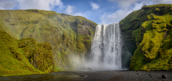 Skogafoss waterfall in Iceland on a summer's day. The Skogafoss waterfall is one of Iceland's most famous waterfalls and tourist attractions.