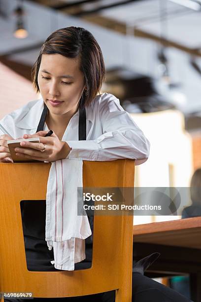 Asian Waitress Reviewing Tickets In Restaurant After Closing Stock Photo - Download Image Now