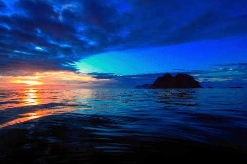 The island Værøy in midnight sun overlooking the Lofoten on the moskenstraumen in the background