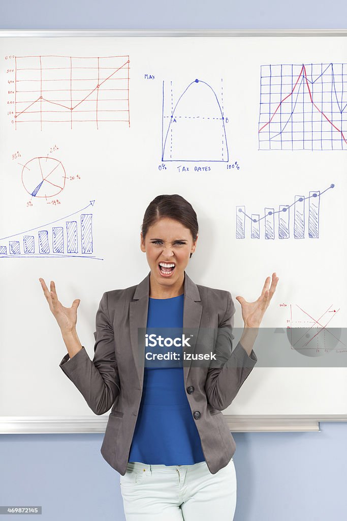 Frustrated female teacher Portrait of screaming female teacher standing in front of whiteboard. Furious Stock Photo