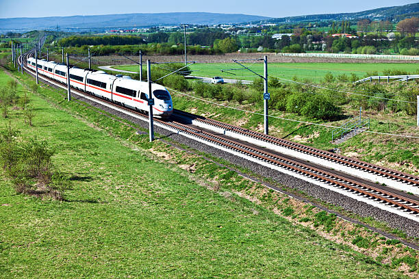 istock View of a high-speed train passing by an open green area 469873703