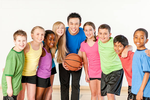 istock PE teacher with kids playing basketball 469875299