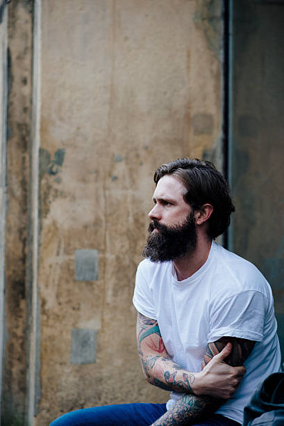 istock Cool Guy with full beard and tattoos in thought 469876591