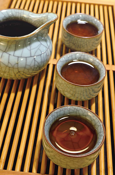 Tea Ceremony Three cups of black tea and teapot from tea ceremony. oolong tea stock pictures, royalty-free photos & images