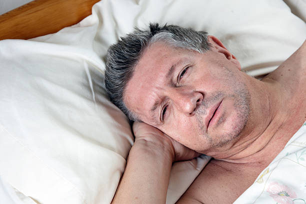 istock Mature man half asleep in bed 469879397