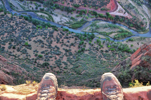 Man's feet on the edge of rock cliff
