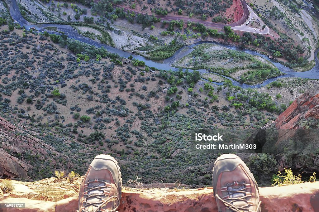 Man's feet on the edge of rock cliff Cliff Stock Photo