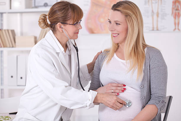 schwangere frau mit arzt-büro. - human pregnancy midwife visit healthcare and medicine stock-fotos und bilder