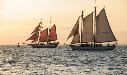 Two schooners sail off the coast of Key West, Florida at sunset.