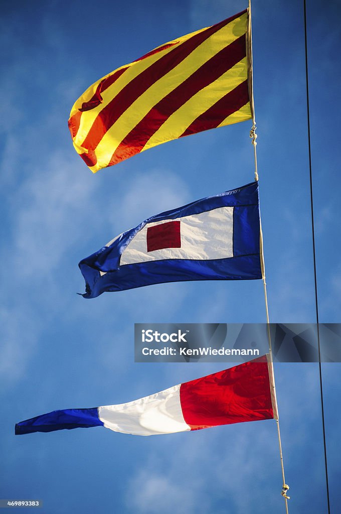 Ships Flags Colorful nautical ship's flags flutter in a sea breeze. The pennants represent, from top to bottom "Y", "W" "3" Alphabet Stock Photo