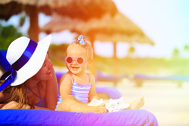 istock mother and cute little daughter having fun on summer beach 469899022