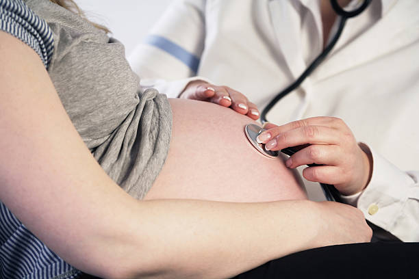 Médico examinar una mujer embarazada - foto de stock