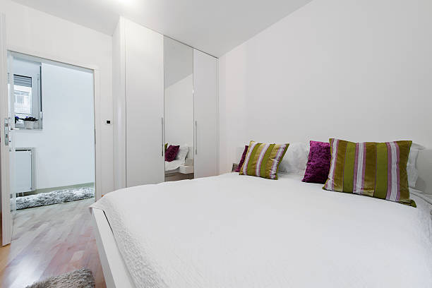 istock Interior of white bedroom with green decorativ pillows 469900830