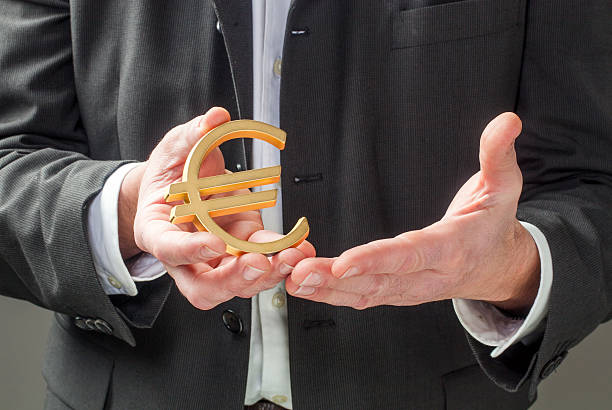 istock businessman holding Euro symbol 469902956