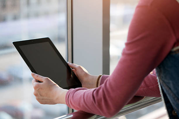 istock woman holding and using tablet pc outdoors in the city 469903720