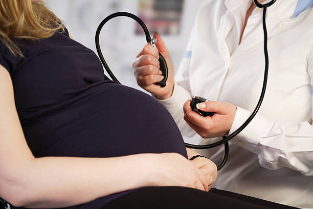 Mujer embarazada con su control de la presión arterial - foto de stock