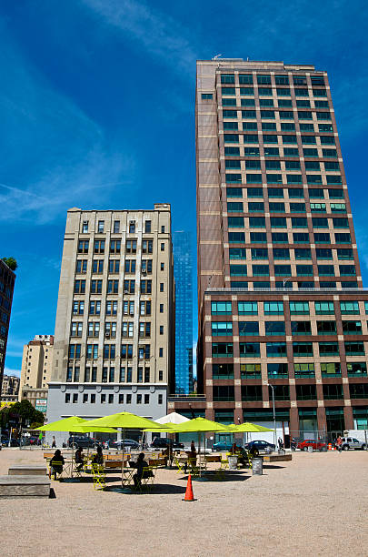 Temporary outdoor eating area, Lower Manhattan Cityscape, NYC New York City, USA - August 05, 2013: People using a temporary eating and relaxation area set up in a vacant lot nearby Lower Manhattan office buildings. 21st century style stock pictures, royalty-free photos & images