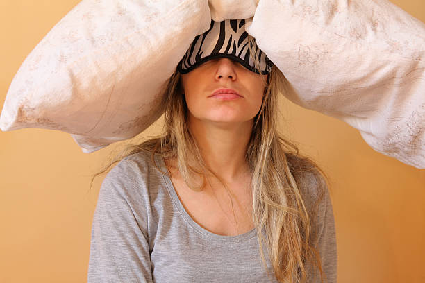 Young women with pillow Sleepy young women with pillow and sleeping eye mask still on. hangover stock pictures, royalty-free photos & images