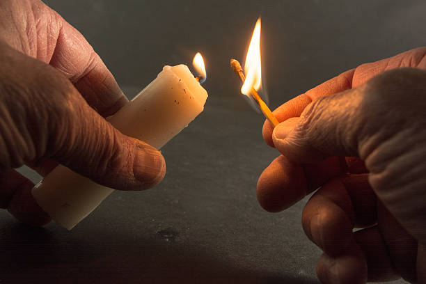 istock Lighting an emergency candle with a wooden match. Black background. 469905606