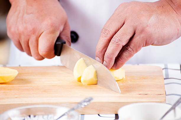 istock Chef cutting Potato on wooden broad 469906030