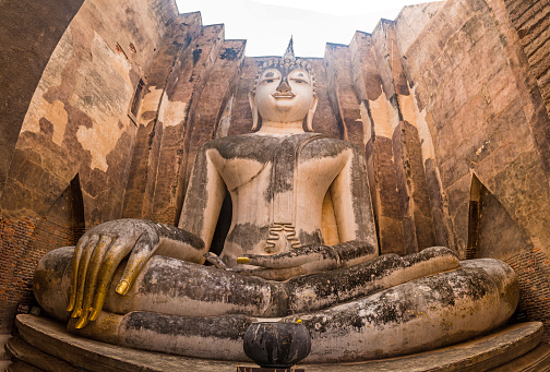 Magnificient statue of enormous sized lord Buddha in seated posture at Wat Si Chum temple in north Sukhothai, Thailand.
