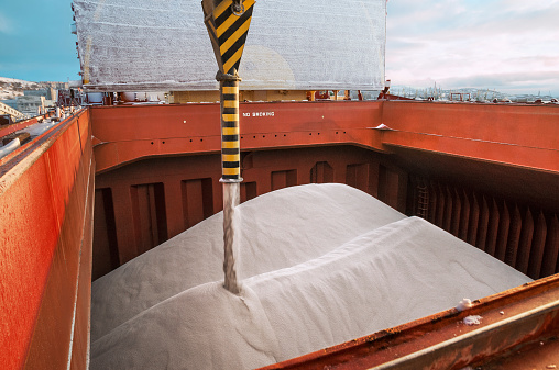 Loading fertilizer into the hold of the ship shiploader  (close-up)