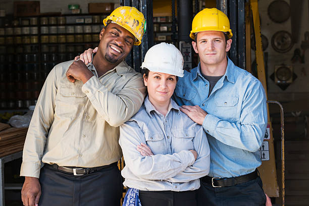 multi-ethnischen fabrik arbeiter mit weiblichen chef - horizontal female with group of males posing looking at camera stock-fotos und bilder