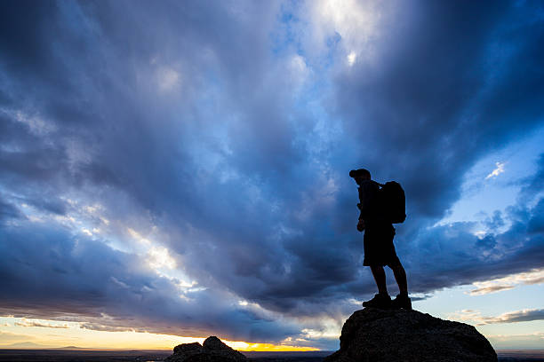 atardecer silueta hombre cielo dramático - travel destinations mountain hiking profile fotografías e imágenes de stock