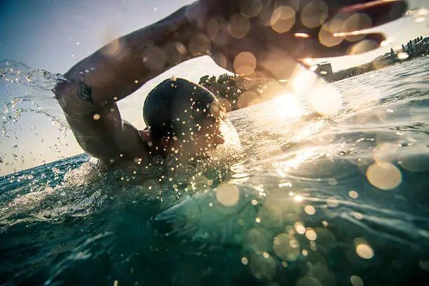 Young man swimming front crawl