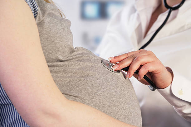Médico examinar una mujer embarazada - foto de stock