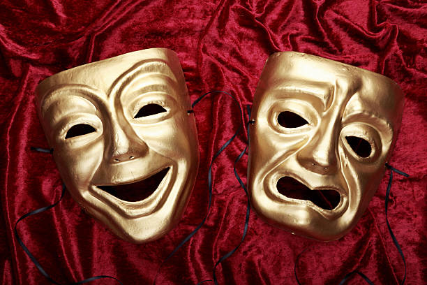 Tragic and comedic masks on red velvet stock photo