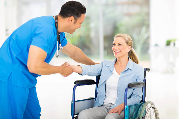 istock mid age medical doctor greeting disabled patient 469910822
