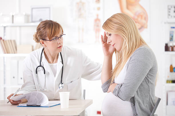 donna incinta in ambulatorio medico. - human pregnancy midwife healthcare and medicine visit foto e immagini stock