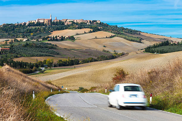 voiture sur la route sinueuse, pienza en arrière-plan, toscane, italie - pienza tuscany italy landscape photos et images de collection