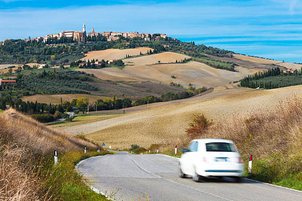 Car on Winding Road, Pienza in Background, Tuscany, Italy stock photo
