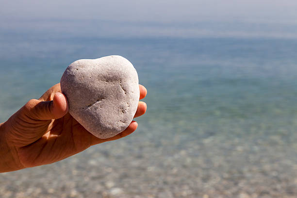 istock Hand holding a natural heart-shaped stone 469916018