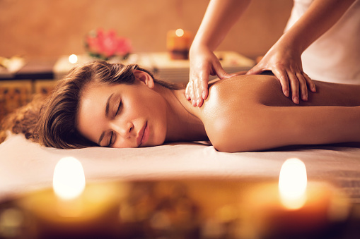 Mujer joven relajante en back sesión de masajes en el spa. photo