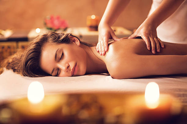 mujer joven relajante en back sesión de masajes en el spa. - cuidado del cuerpo fotos fotografías e imágenes de stock