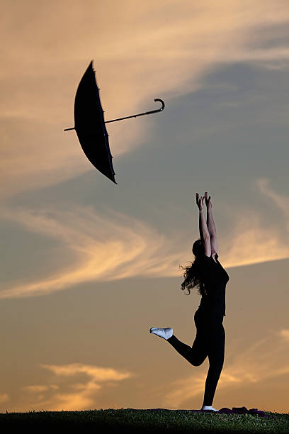istock Young woman outdoors jumping with umbrella 469916250