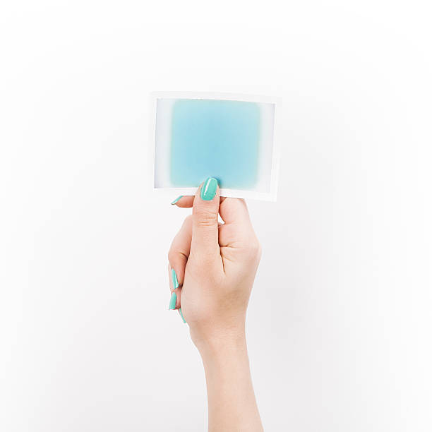 istock Female hand holding polaroid with blue blank space 469917282