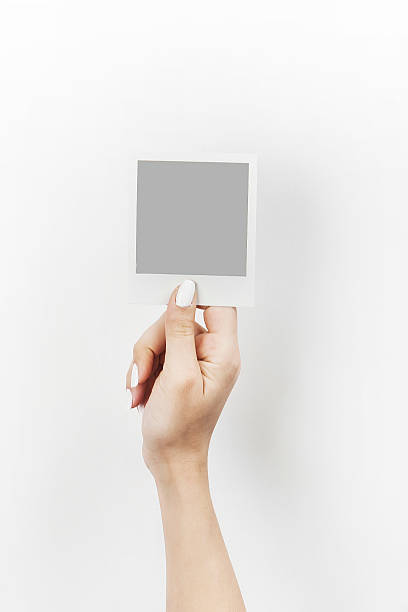 istock Female hand holding polaroid with grey blank space 469917302