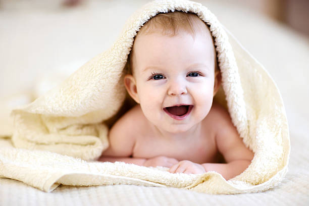 istock Laughing baby wrapped in the towel on bed 469919004