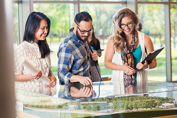 Diverse young design team studying architectural model duirng meeting