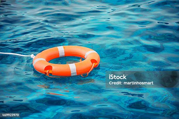 Lifebuoy Resting On Top Of Blue Waters Stock Photo - Download Image Now - Life Belt, Swimming Pool, 2015