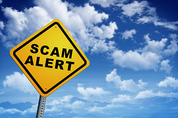 istock Yellow sign reading 'scam alert' against blue sky 469925818