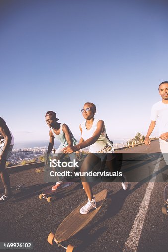 istock Skater girl downhill racing on her longboard with friends 469926102