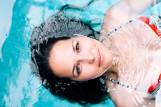 istock Beautiful woman floating in pool 469926699