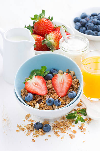 istock healthy breakfast - granola, fresh berries, orange juice 469927152