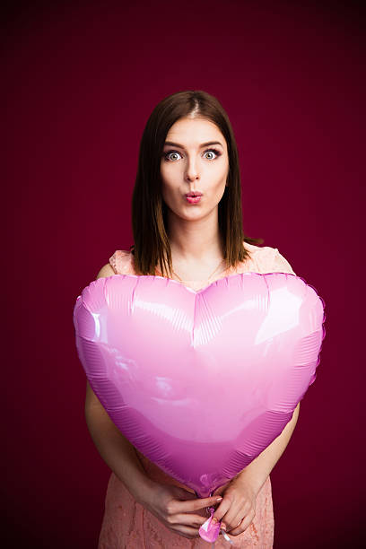 istock woman holding heart shaped balloon 469927432